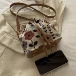 Sac seau blanc pour femme avec motif floral vibrant, fermeture à cordon réglable, bandoulière/sac à main convertible doublé en polyester