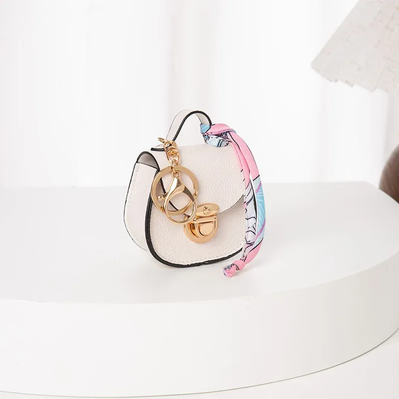 pochette porte-clés multifonctionnelle et portable, tendance et polyvalente, en forme de selle, avec porte-monnaie et étui de rangement pour écouteurs sans fil.