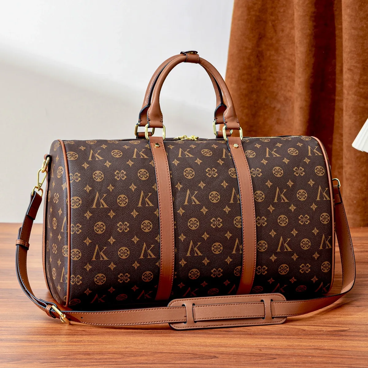 sac de voyage marron à motif monogramme, anses supérieures, bandoulière réglable, poche avant et détails dorés