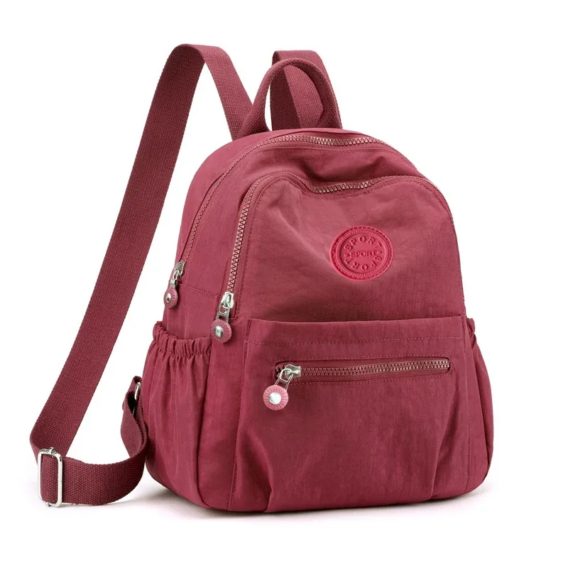 sac à dos de style neutre pour hommes et femmes, adapté aux voyages et à la photographie en nylon, avec un logo rond.