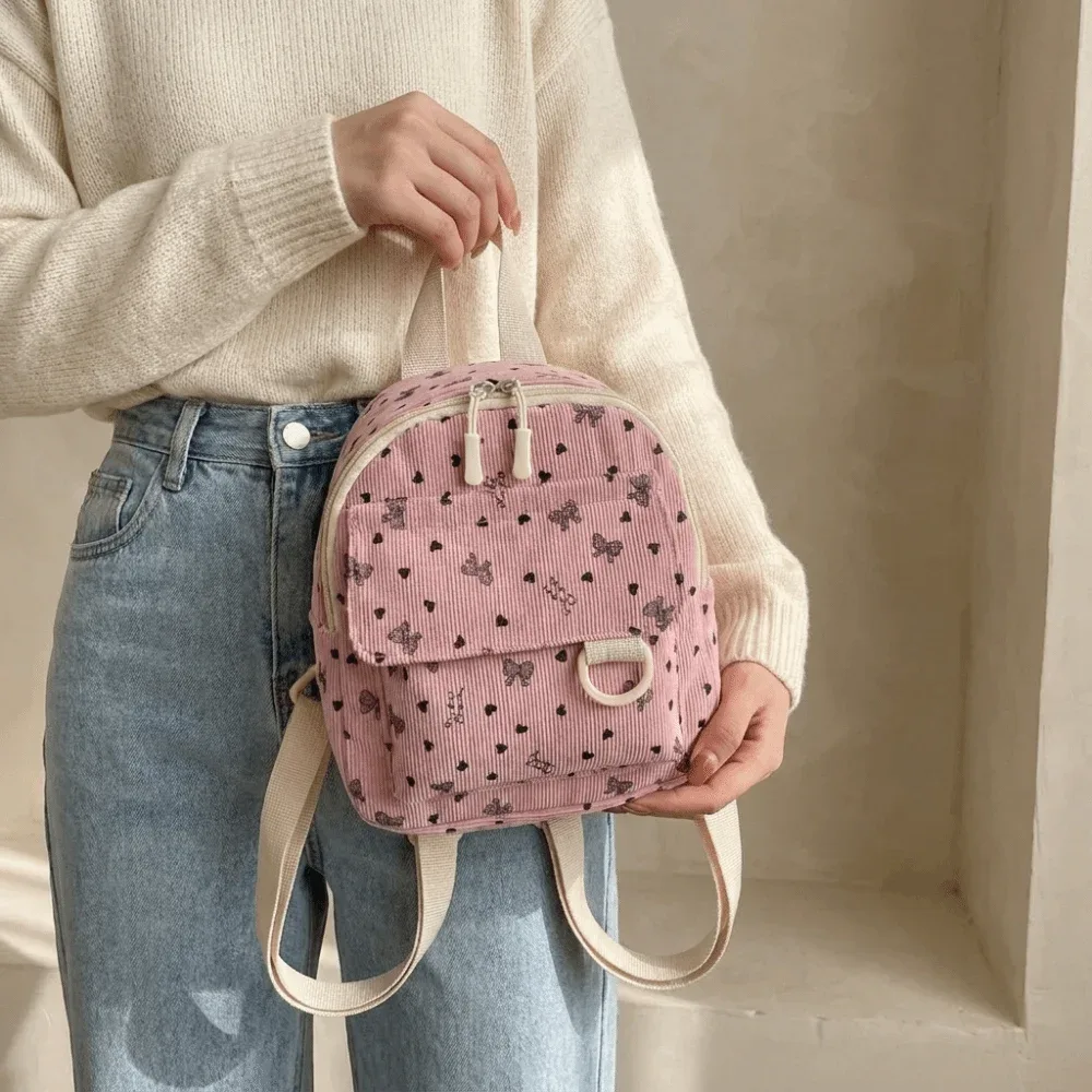 Mini sac à dos en velours côtelé léger avec imprimé cœur et nœud, sac à dos décontracté multi-compartiments à ouverture zippée pour l'école
