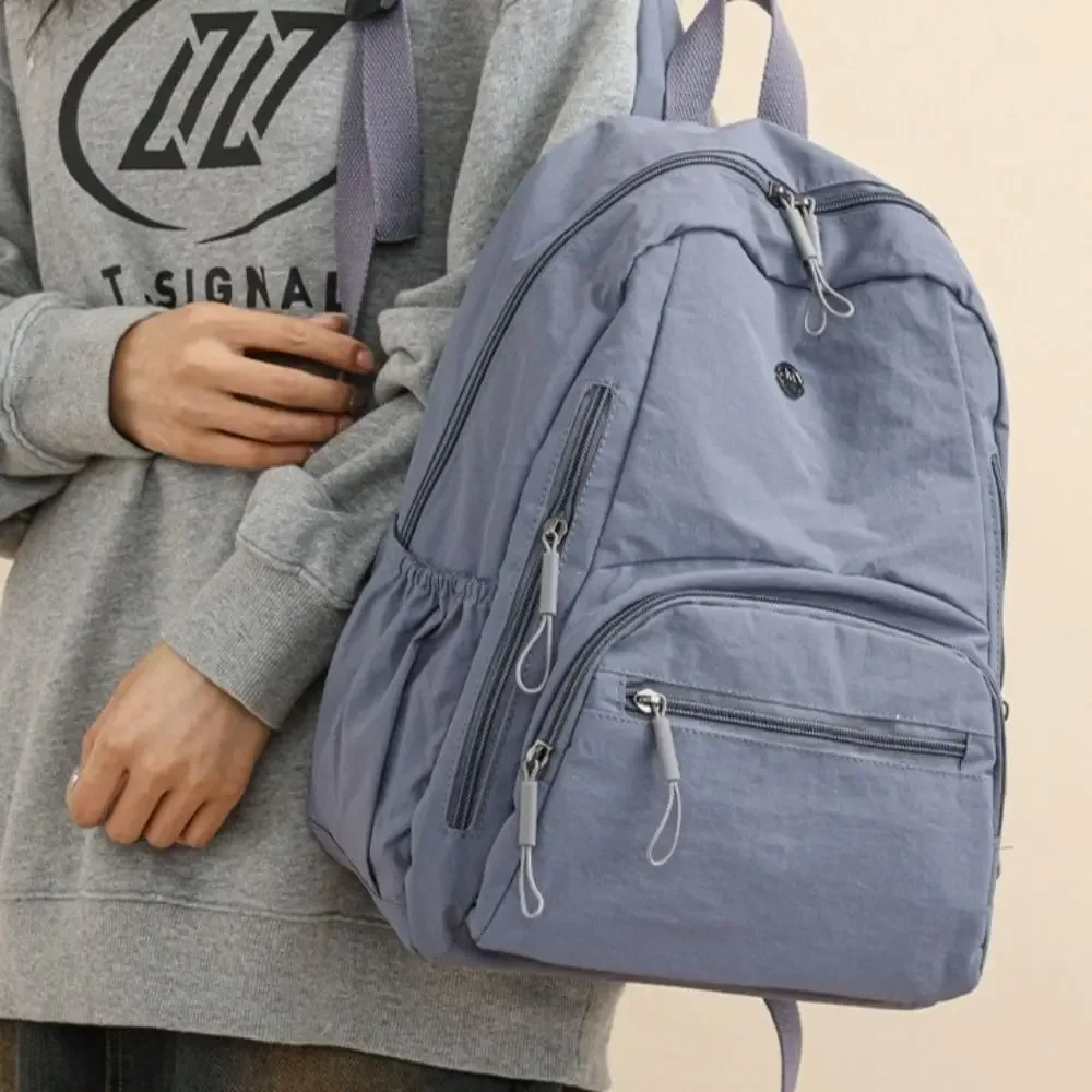 sac à dos minimaliste en nylon de grande capacité, fermeture éclair sécurisée, sac à dos léger et imperméable pour l'école et les voyages.