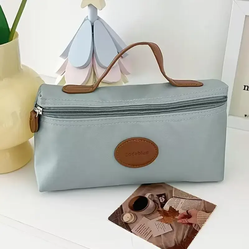 nouvelle trousse de maquillage portable 2026, sac cosmétique à main grande capacité en nylon, trousse de toilette de voyage pour femme, sac de rangement de voyage