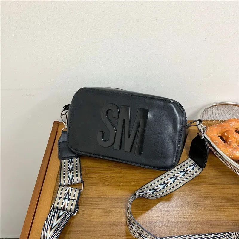 Sac bandoulière minimaliste uni Steve Madden pour femmes, avec larges bretelles et design élégant de sac pour appareil photo.