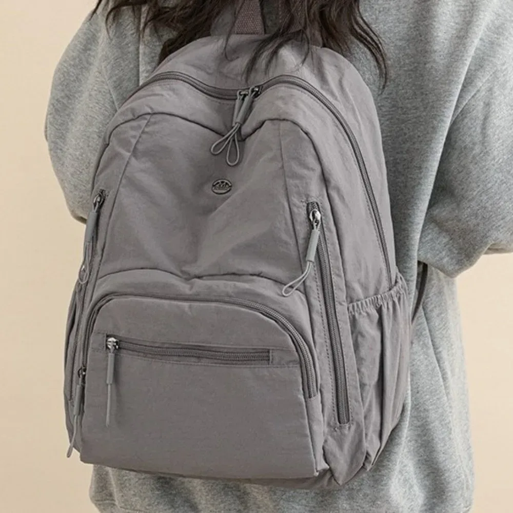 Sac à dos minimaliste en nylon de grande capacité, fermeture éclair sécurisée, sac à dos léger et imperméable pour l'école et les voyages.
