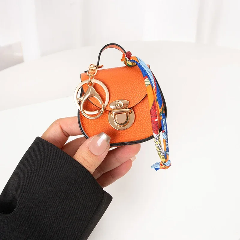 pochette porte-clés multifonctionnelle et portable, tendance et polyvalente, en forme de selle, avec porte-monnaie et étui de rangement pour écouteurs sans fil.
