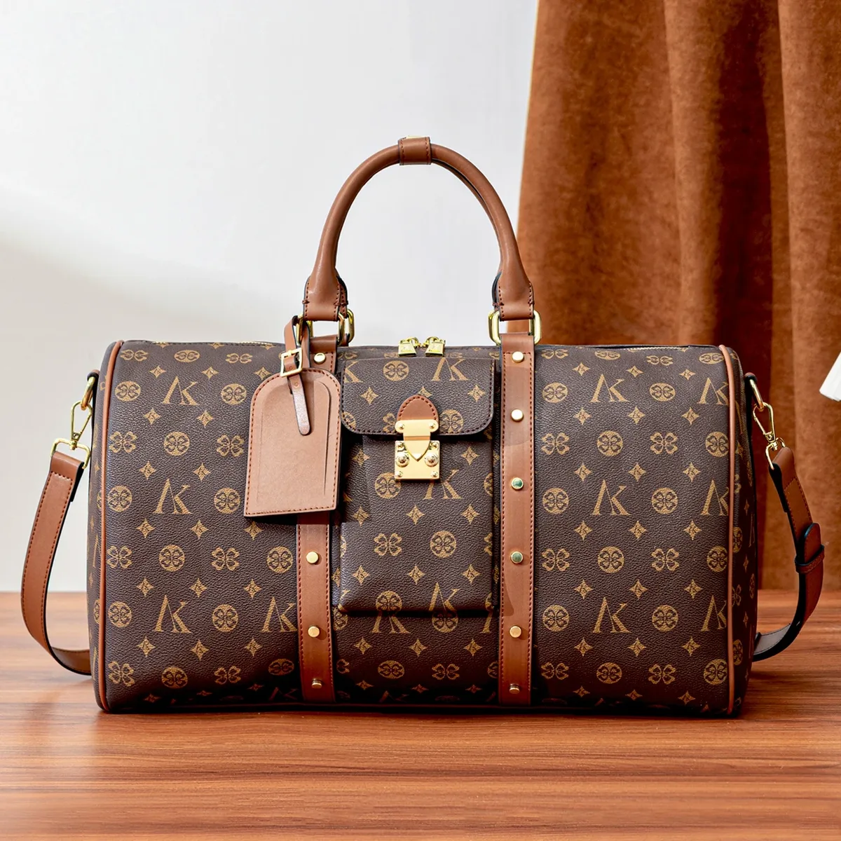 sac de voyage marron à motif monogramme, anses supérieures, bandoulière réglable, poche avant et détails dorés