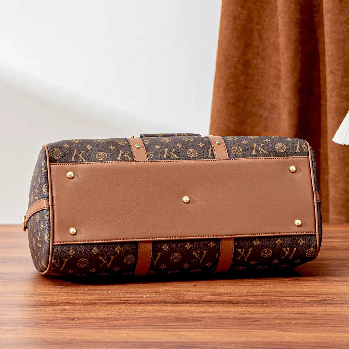 sac de voyage marron à motif monogramme, anses supérieures, bandoulière réglable, poche avant et détails dorés