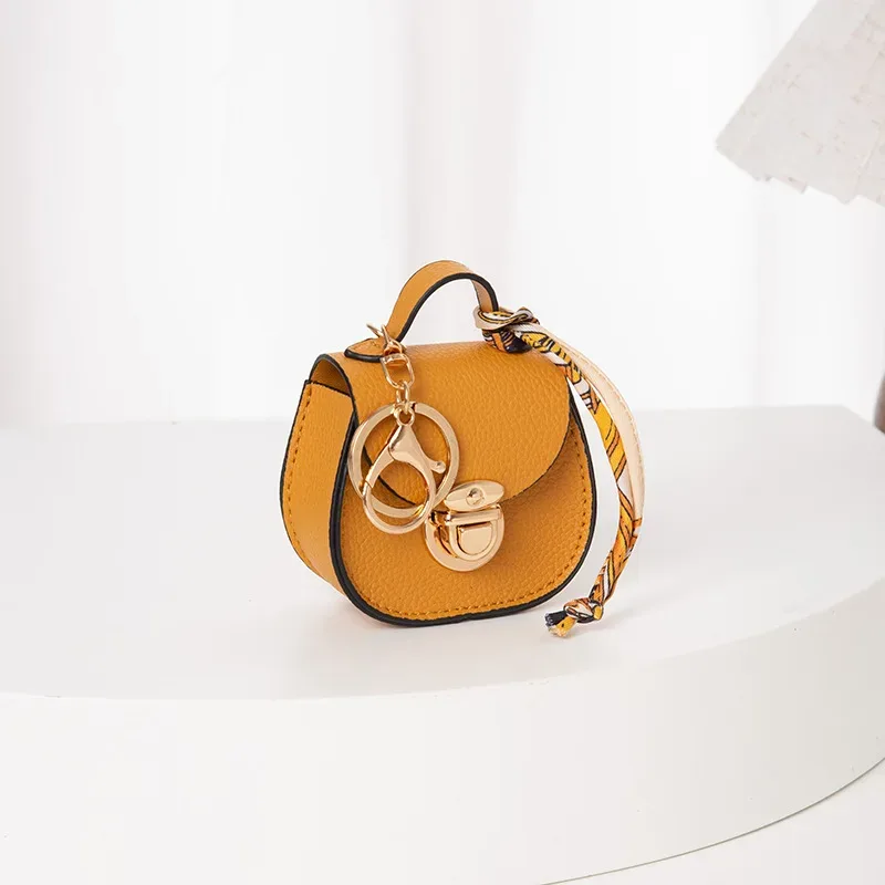 pochette porte-clés multifonctionnelle et portable, tendance et polyvalente, en forme de selle, avec porte-monnaie et étui de rangement pour écouteurs sans fil.